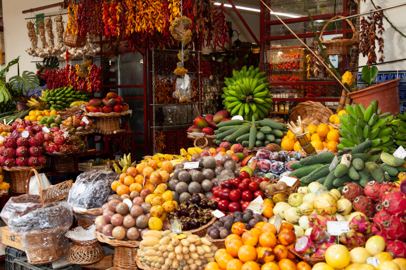 Bunter Obst- und Gewürzmarkt Mercado dos Lavradores in Funchal auf Madeira mit exotischen Früchten und Bananen