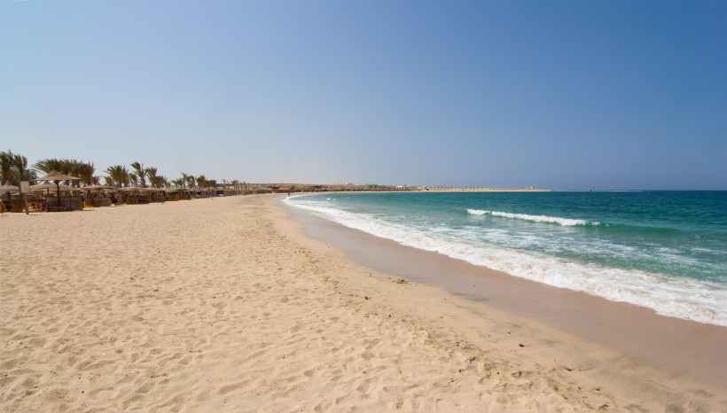 Weitläufiger Sandstrand in Marsa Alam mit sanften Wellen und ruhiger Atmosphäre am Roten Meer