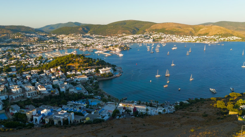 Panoramablick auf die Bucht von Bodrum mit Segelbooten, Hafen, weißer Altstadt und umliegenden Hügeln
