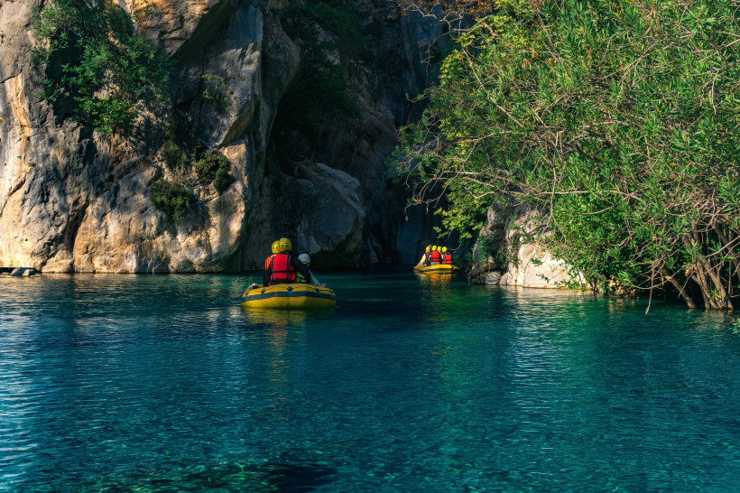 Touristen beim Rafting im Göynük-Canyon nahe Kemer, klares türkisblaues Wasser, hohe Felswände und grüne Vegetation