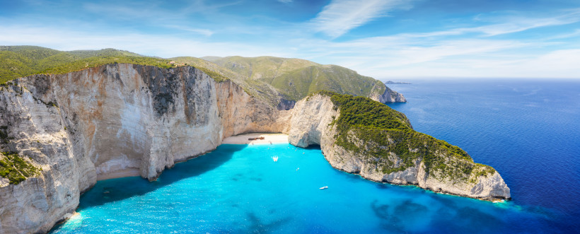 Zakynthos ein kleiner Strand neben einem riesigen Berg und Booten