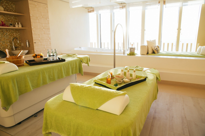 Wellness-Suite auf der AIDAperla mit Massageliegen, Pflegeprodukten und Badewanne am Fenster