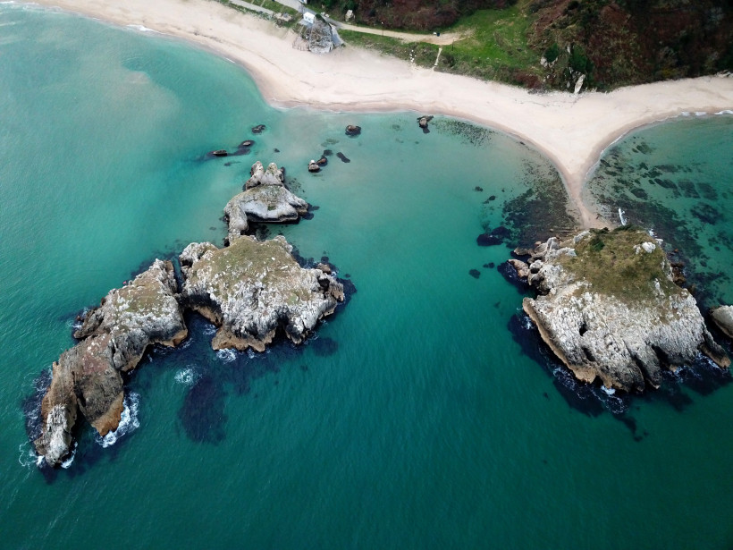 Luftaufnahme der Bucht Sardala mit Sandstrand, türkisfarbenem Wasser und Felsen im Meer
