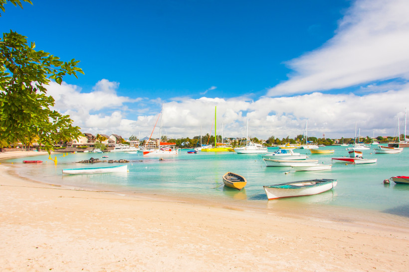 Boote im türkisfarbenen Wasser am Strand von Grand Baie, Mauritius