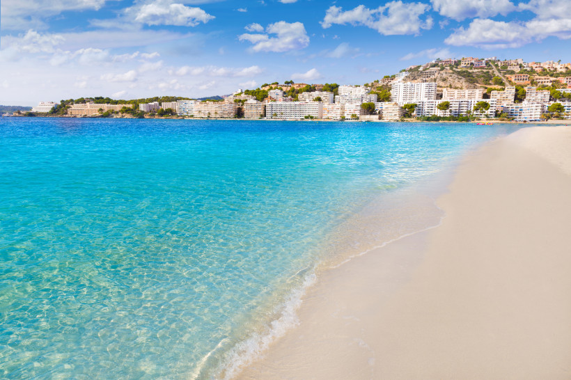 Santa Ponsa Strand mit türkisfarbenem Meer, Sandstrand und Küstenbebauung im Hintergrund