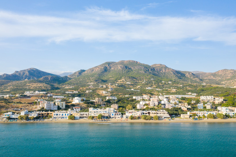 Küstenort Analipsi mit Strand und Häusern vor einem Bergmassiv