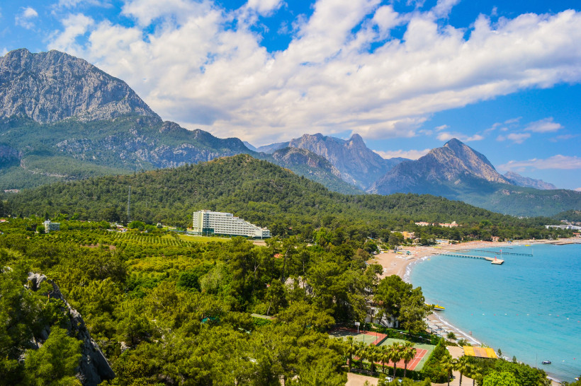 Strand von Kemer mit türkisblauem Meer, Pinienwäldern und dem Taurusgebirge im Hintergrund