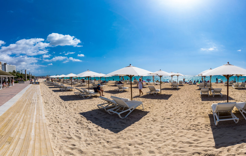 Playa de Palma – Sonniger Strandtag auf Mallorca mit Sonnenschirmen und Meerblick Playa de Palma Mallorca mit Sonnenliegen und Sonnenschirmen an einem sonnigen Tag am Mittelmeer