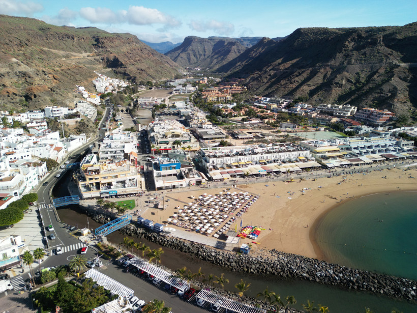 Puerto de Mogán: Blick auf Strand und Ortszentrum zwischen den Bergen Luftaufnahme von Puerto de Mogán mit Strand, Promenade und Bergen im Hintergrund