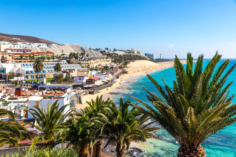 Küstenansicht von Morro Jable auf Fuerteventura mit Sandstrand, Promenade und Hotels am Hang