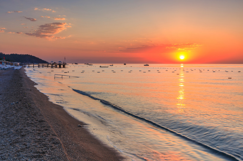 Sonnenuntergang am Strand von Kemer mit ruhigem Meer und warmen Farben