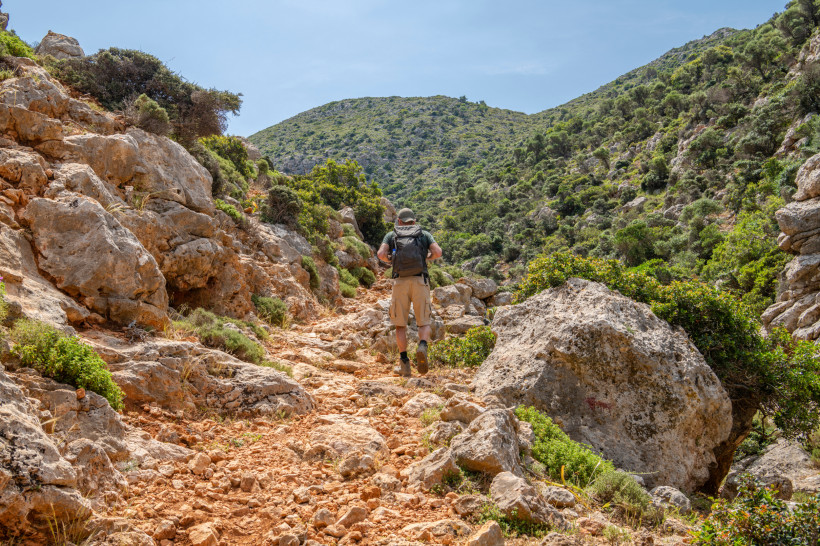 Kreta: Wanderwege und Berglandschaften bei Stalida Wanderer auf steinigem Bergpfad in Kretas Natur – Aktivurlaub und Ausflüge wie rund um Stalida