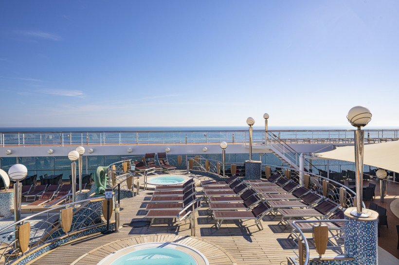 Sonnendeck mit Liegen und Whirlpools im Poolbereich Acapulco auf der MSC Orchestra, Blick aufs Meer