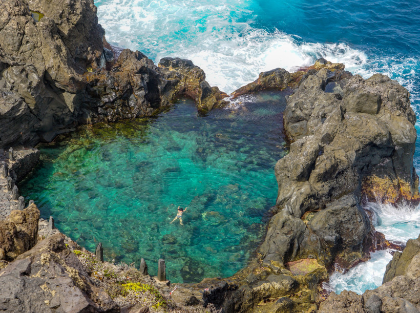 Natürlicher Meerwasserpool Charco de la Laja auf Teneriffa, umgeben von Felsen und Brandung