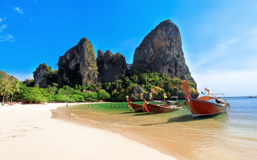 Railay Beach Krabi – Traumstrand mit Longtail-Booten Railay Beach in Krabi mit weißem Sand, türkisblauem Wasser, Longtail-Booten und spektakulären Kalksteinfelsen in Thailand.