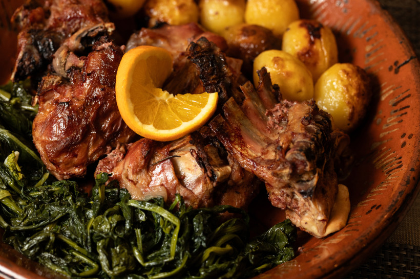 Katsiki sto fourno: im Ofen gebratenes Ziegenfleisch mit Kartoffeln, Blattgemüse und Orangenscheibe