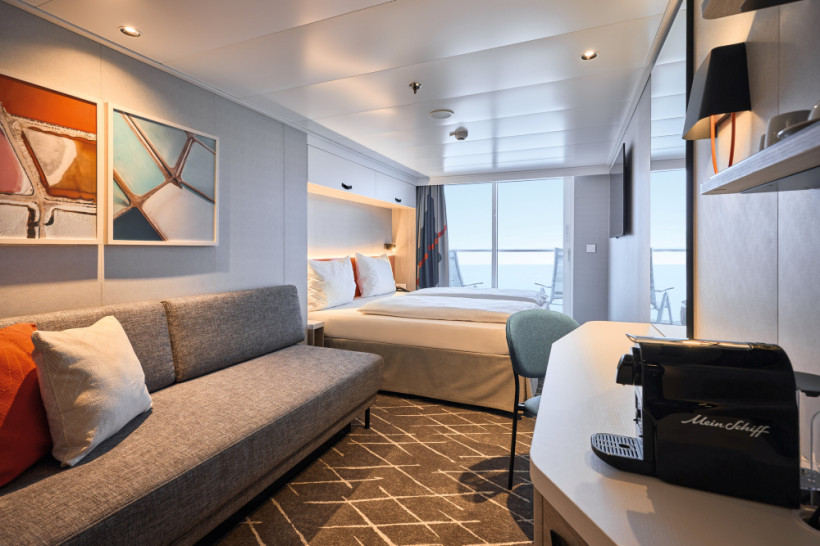 Mein Schiff Relax – Balkonkabine mit Doppelbett, Sofa und Zugang zum Balkon Balkonkabine auf der Mein Schiff Relax mit Doppelbett, Sofa und Balkonblick aufs Meer