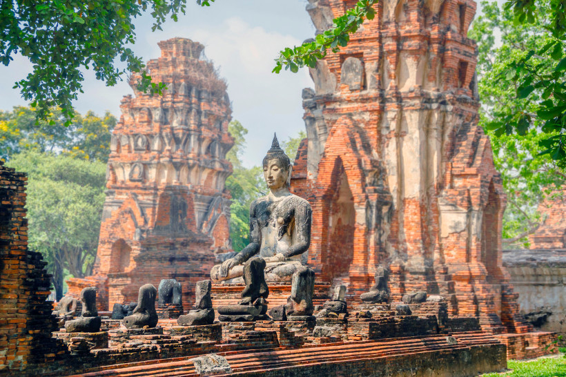 Sitzende Buddha-Statue in den roten Ziegelruinen des Wat Mahathat Tempels in Ayutthaya, Thailand