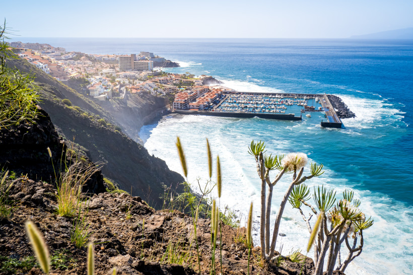 Teneriffa - Playa de los Guíos Puerto de Santiago im Südwesten Teneriffas: Blick von oben auf Yachthafen, Küstenort mit Hotels und steile Felsen am Atlantik.