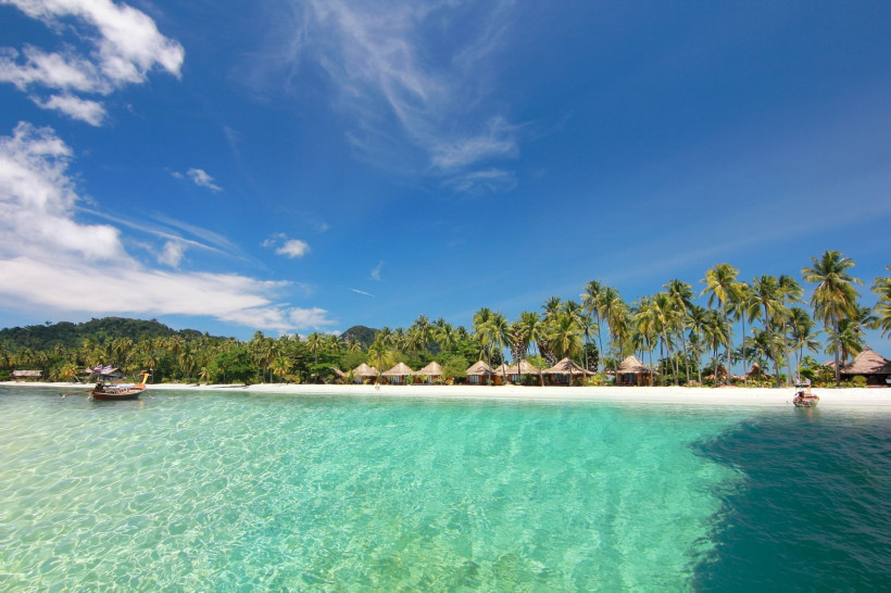 Koh Lipe Strand in Thailand mit Palmen, weißen Sand und kristallklarem türkisblauen Wasser bei Sonnenschein