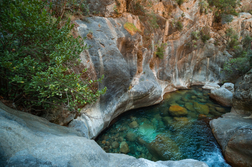 Kristallklares türkisfarbenes Wasser fließt durch glatte Felsen in der Sapadere Schlucht in der Nähe von Alanya – ein beliebtes Naturschutzgebiet in der Türkei.