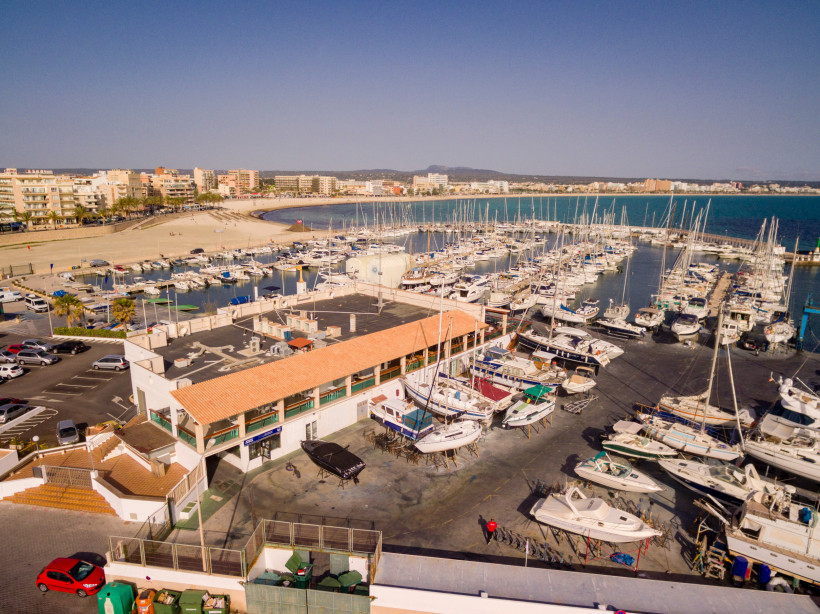 Hafenbecken von Can Pastilla mit Yachten und Strand im Hintergrund