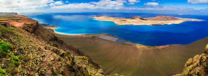Atemberaubender Panoramablick vom Mirador del Río auf La Graciosa – Lanzarote Sehenswürdigkeiten Panoramablick vom Mirador del Río auf die Insel La Graciosa mit türkisblauem Atlantik und spektakulären Klippen auf Lanzarote.