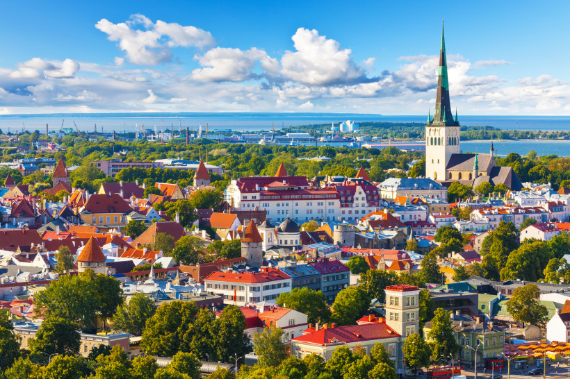 Tallinn: Altstadtpanorama mit Kirchturm, Hafen und Ostsee Blick über die Altstadt von Tallinn mit roten Dächern und Kirchturm, im Hintergrund Hafen und Meer