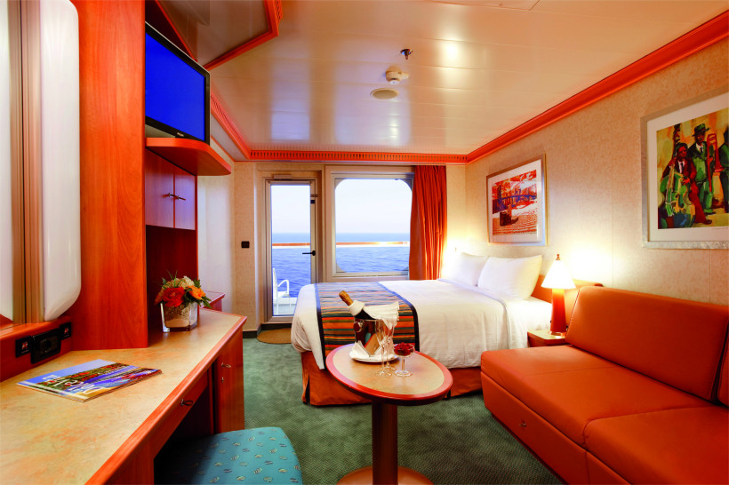 Costa Pacifica – Balkonkabine mit Doppelbett, Sitzbereich und Balkontür zum Meer Balkonkabine auf der Costa Pacifica mit Doppelbett, Sofa und Balkonblick aufs Meer