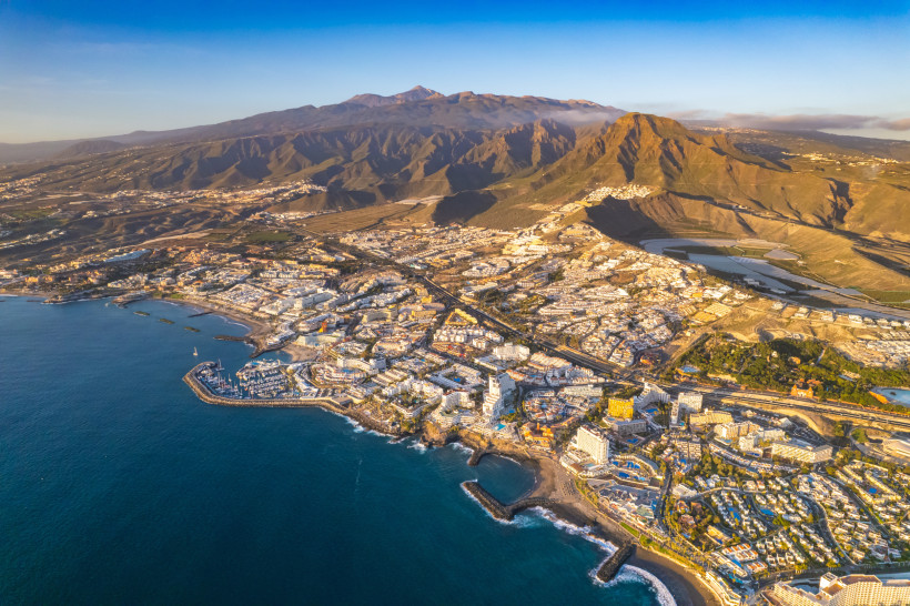 Teneriffa aus der Luft – beeindruckende Küste und Berglandschaft Luftaufnahme der Südküste von Teneriffa mit Stränden, Hotels, Bergen und dem Atlantik. Panoramablick auf Adeje, Küstenorte und vulkanische Landschaft.