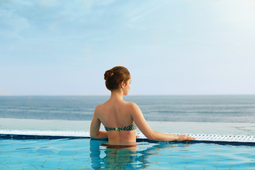 Person im Pool mit Blick auf das Meer, Wellness in Hotels bei Portals Nous