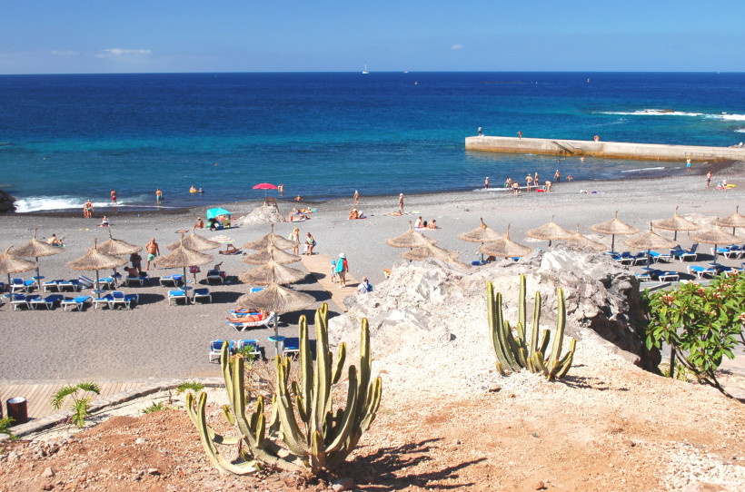 Strand von Callao Salvaje mit Sonnenschirmen, Liegen und Badenden am Meer
