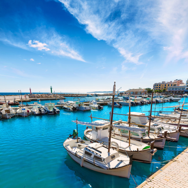 Kleiner Hafen von Cala Bona mit Fischerbooten, ruhigem Wasser und Uferpromenade