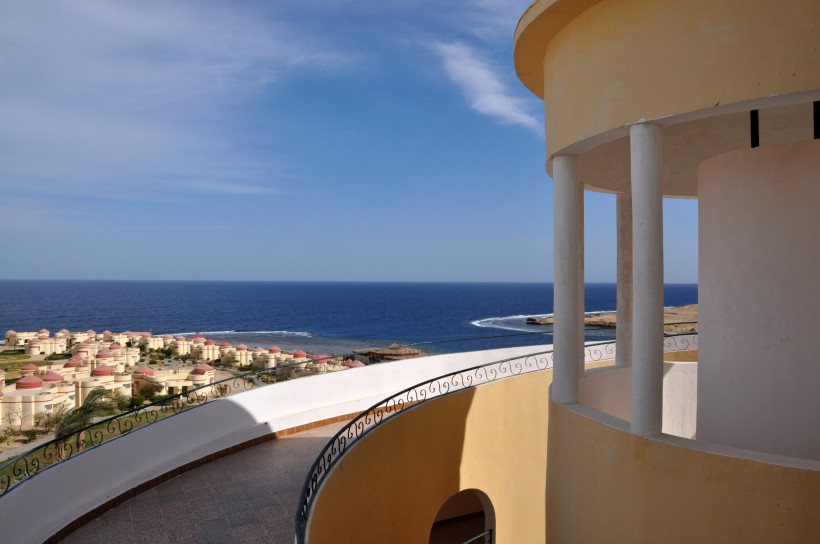 Panoramablick von der Terrasse auf Küste, Meer und Resortanlagen Aussicht von einer Terrasse mit Rundbau auf die Küste und ein Meer mit klaren Wellen
