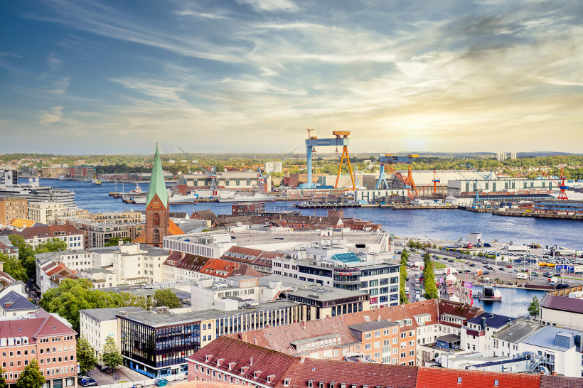 Kiel: Stadtansicht mit Hafen und Werftkränen Blick über Kiel mit Hafenanlagen, Kränen und Kirchturm bei Abendlicht