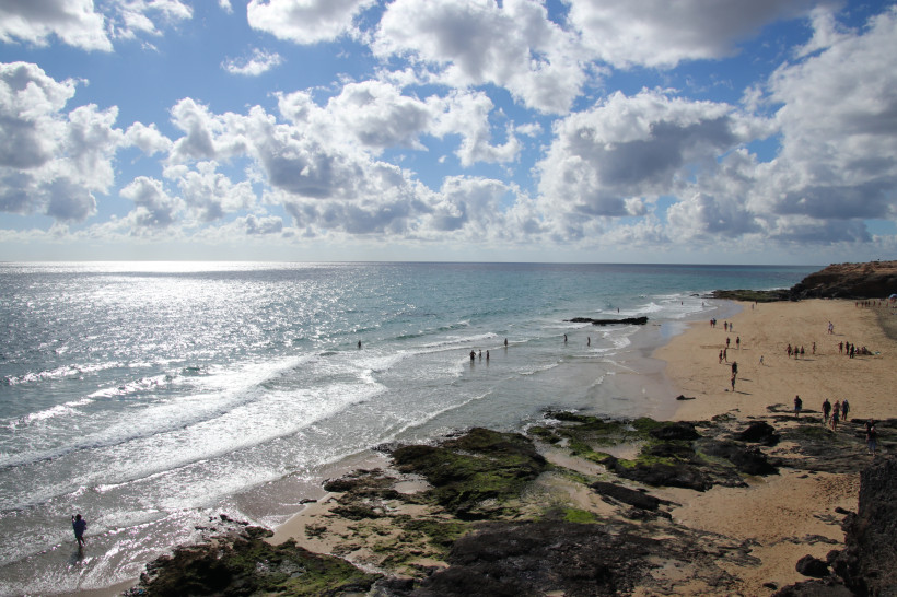 Blick auf den Strand Playa Barca bei Costa Calma mit Sandbucht, Felsen und Wellen am Atlantik