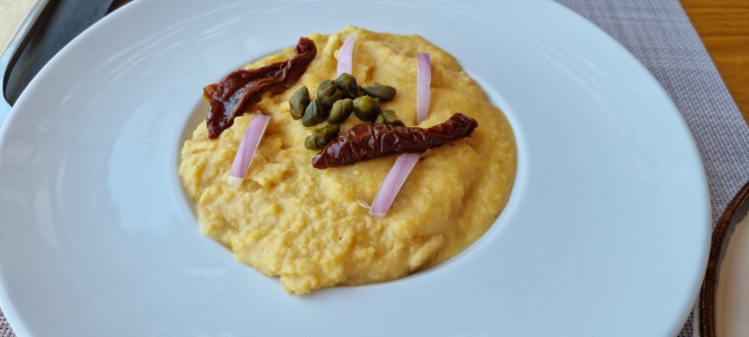 Griechisches Fava-Püree aus gelben Hülsenfrüchten mit Kapern, Zwiebelstreifen und getrockneten Tomaten