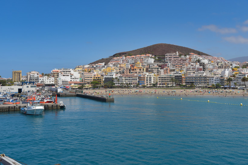 Küstenansicht von Arona auf Teneriffa mit Hafenbecken, Strand und dichter Bebauung am Hang