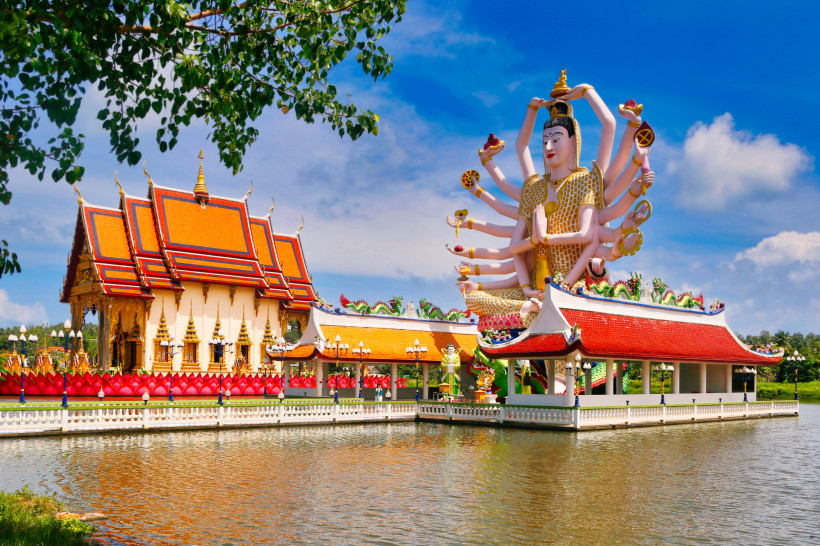 Wat Plai Laem Koh Samui – Tempelanlage mit Guan-Yin-Statue Farbenprächtige Tempelanlage Wat Plai Laem auf Koh Samui mit großer Guan-Yin-Statue und roten Dächern am Wasser.
