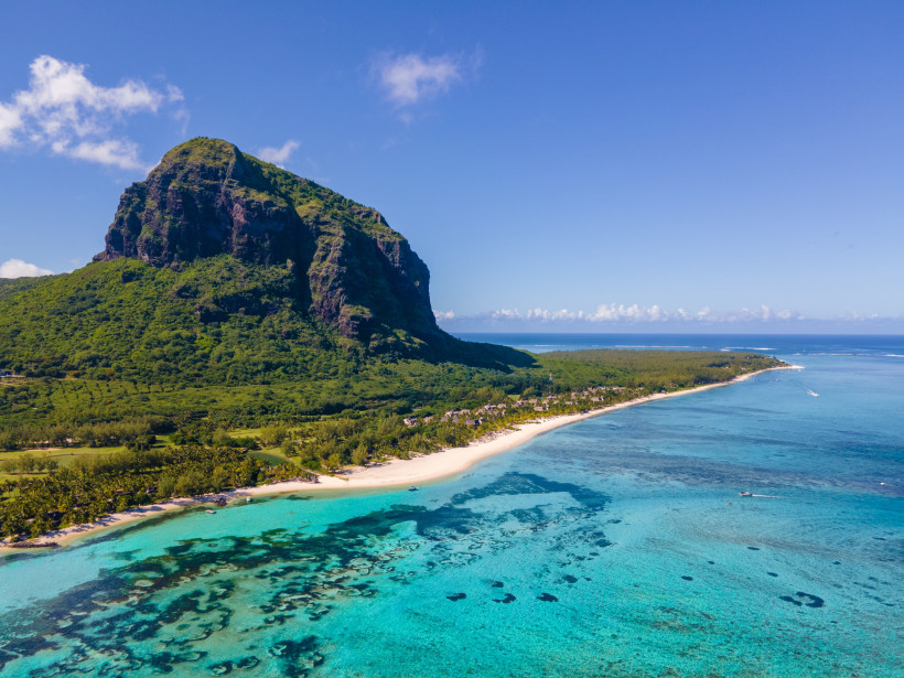 Der Le Morne Brabant Berg auf Mauritius mit weißem Sandstrand und türkisfarbenem Meer aus der Luft gesehen
