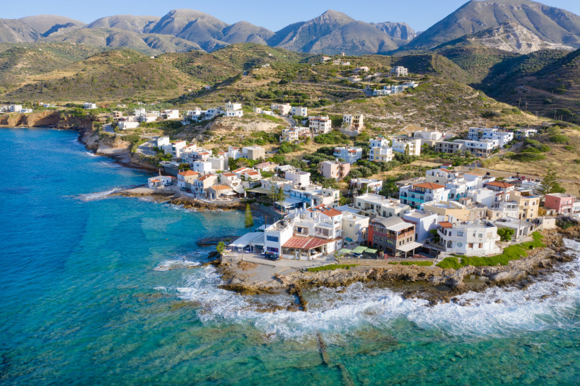 Malerischer Küstenort auf Kreta mit Häusern am Hang und Blick auf das Meer