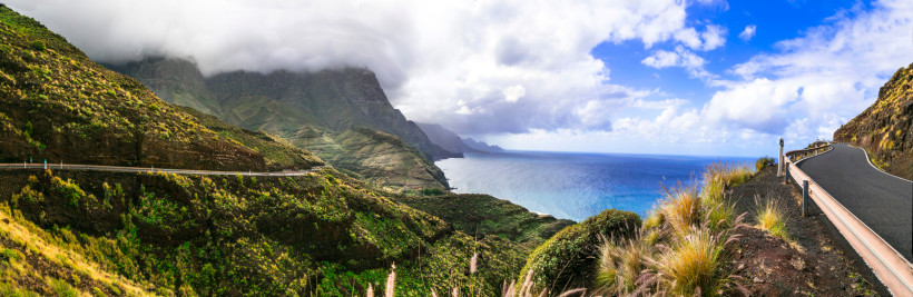 Panoramastraße an der Westküste Gran Canarias Atemberaubender Panoramablick auf die kurvenreiche Küstenstraße im Westen Gran Canarias mit steilen Berghängen, üppiger Vegetation und Blick auf den tiefblauen Atlantik – ein Highlight für Roadtrips und Naturfreunde.