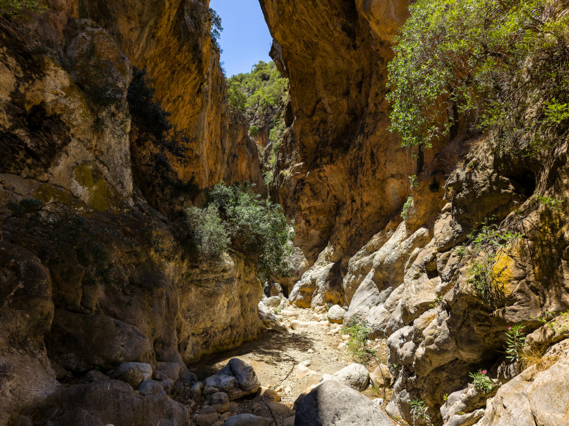 Felsenge der Sarakina-Schlucht mit steilen, sonnigen Felswänden und Geröllbett