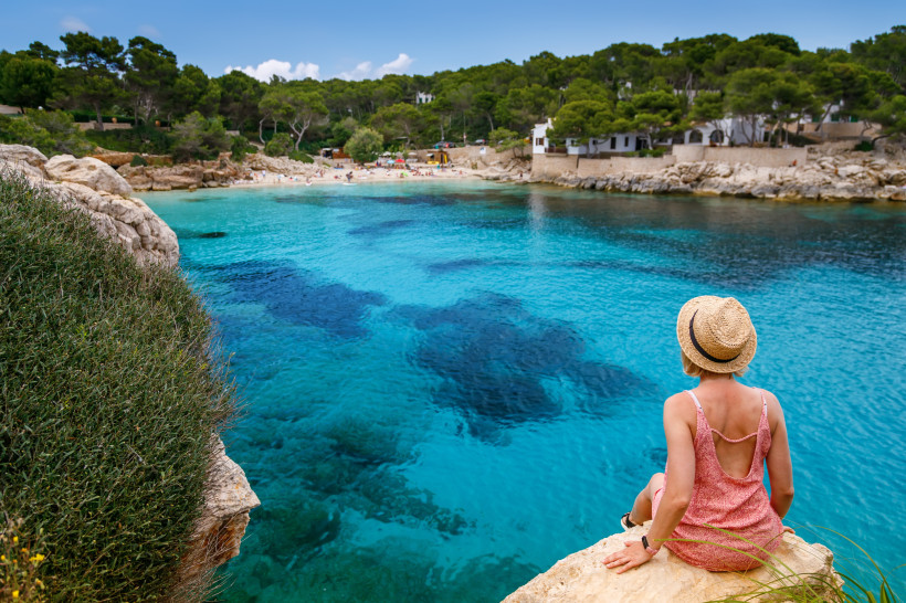 Cala Gat in Cala Ratjada auf Mallorca mit kristallklarem, türkisblauem Wasser, Felsenbucht und Pinien im Hintergrund – idyllischer kleiner Strand an der Ostküste