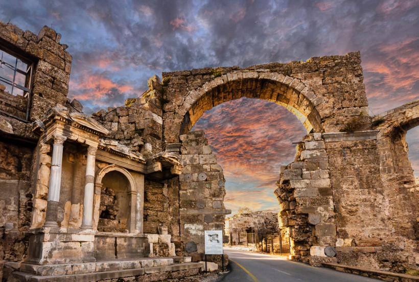 Antike Ruinen der Stadt Side mit historischem Triumphbogen bei stimmungsvoller Abendbeleuchtung