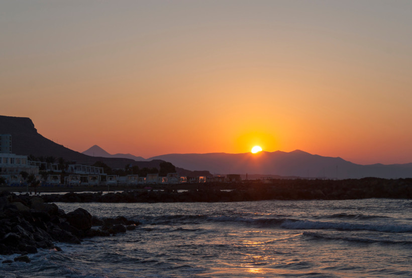 Sonnenuntergang bei Kokkini Hani mit Bergsilhouette und Wellen am Meer