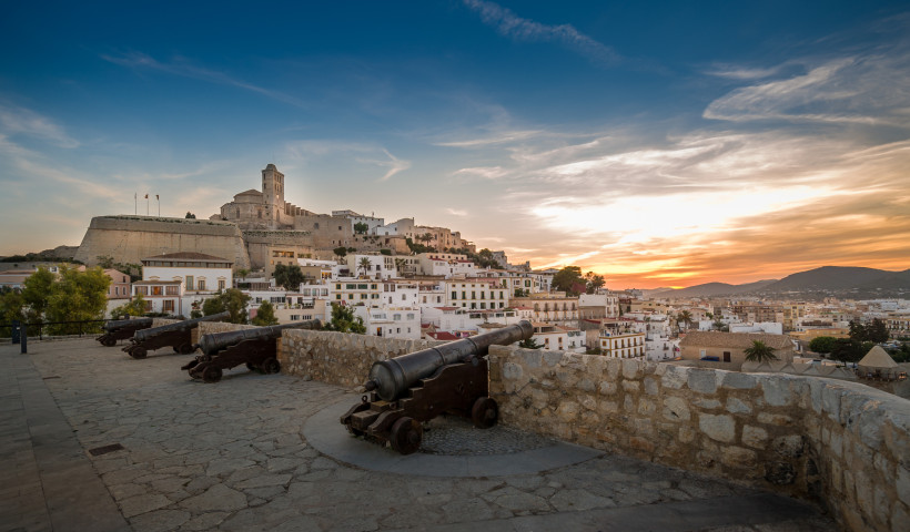 Blick auf Dalt Vila in Ibiza-Stadt mit Festung und Kanonen bei Abendlicht Dalt Vila in Ibiza-Stadt mit Festungsmauer, Kanonen und Altstadthäusern bei Sonnenuntergang