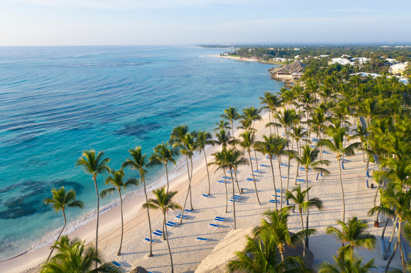 Dominikanische Republik Weißer Sandstrand in Punta Cana mit Palmen, Sonnenliegen und türkisblauem Meer in der Dominikanischen Republik