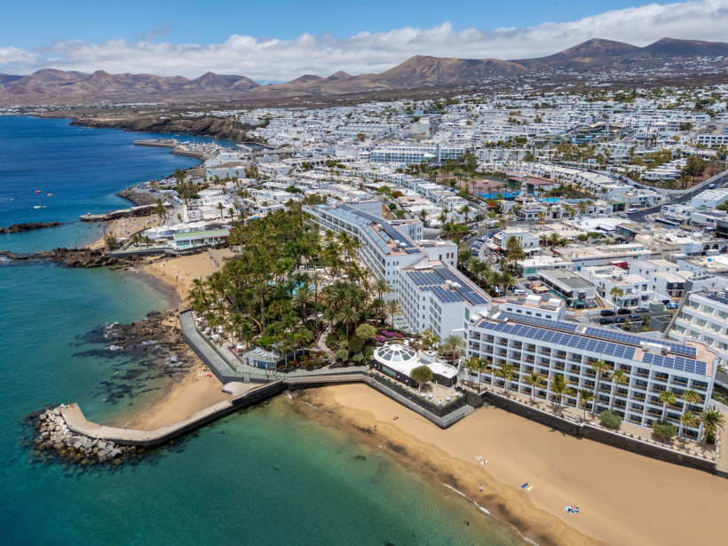Puerto del Carmen aus der Luft – Goldene Strände Luftaufnahme von Puerto del Carmen auf Lanzarote mit goldenen Stränden, Hotels, Promenade und Blick auf die Vulkanlandschaft.