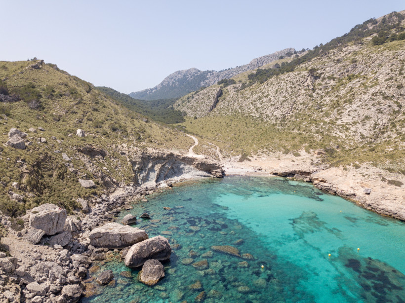 Cala Bóquer mit türkisfarbenem Wasser, Felsufern und schmalem Kiesstrand am Ende des Vall de Bóquer auf Mallorca.